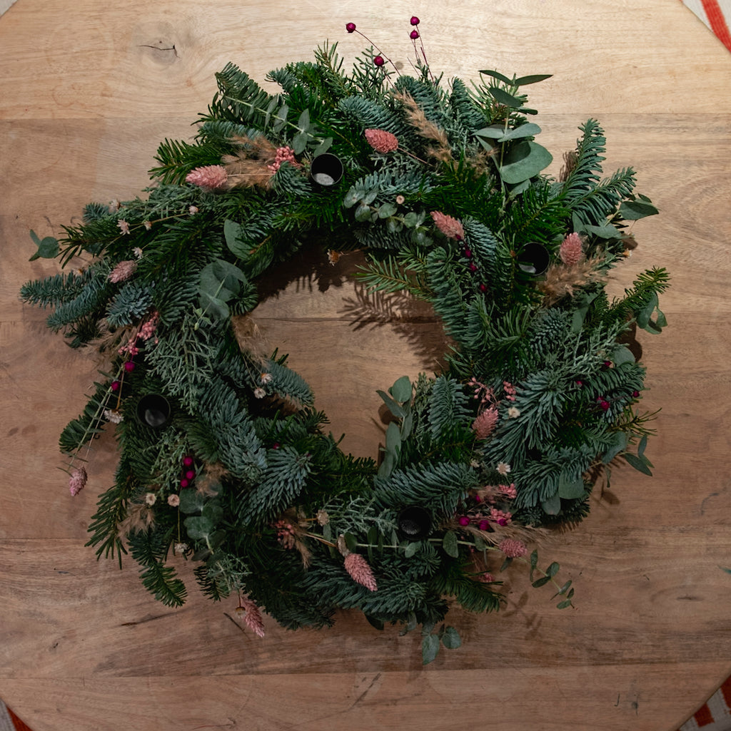 StraightCurls-Adventskranz-Workshop FFB Emmering: grüner Kranz mit Eukalyptus, rosa-rot, auf Holz.