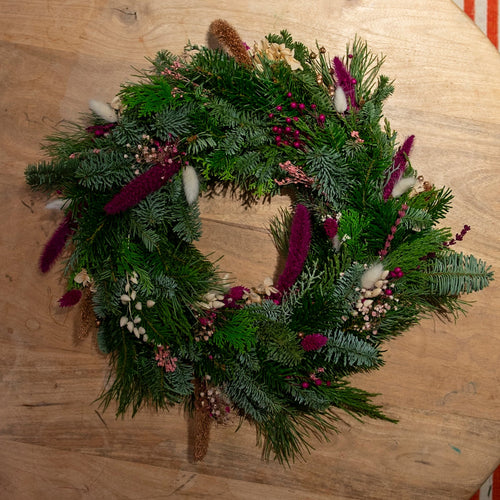 Beim Adventskranz-Workshop FFB Emmering wird ein StraightCurls-Kranz mit violetten und weißen Akzenten ausgestellt.