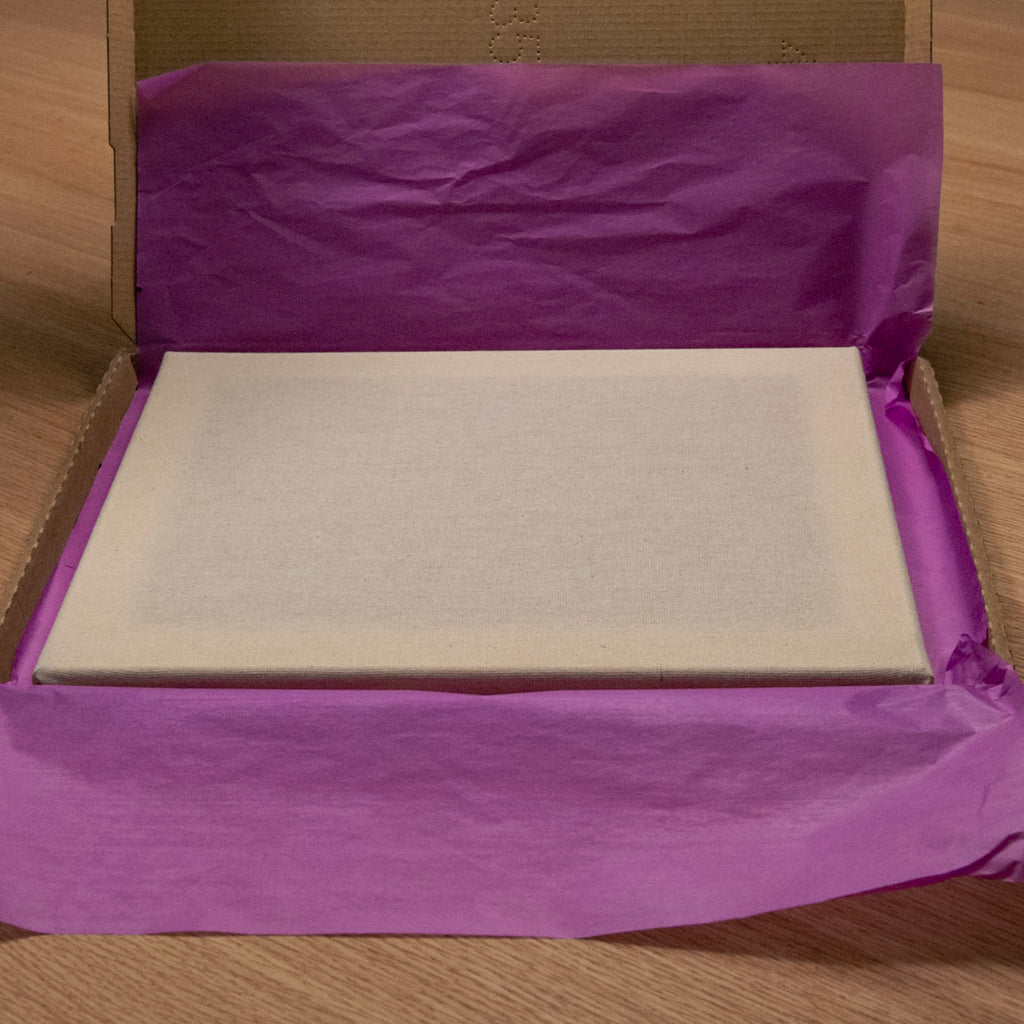 Der Straightcurls Punch Needle-Keilrahmen (24 x 30 cm), handbespannt, befindet sich in einer mit violettem Seidenpapier ausgekleideten Schachtel.