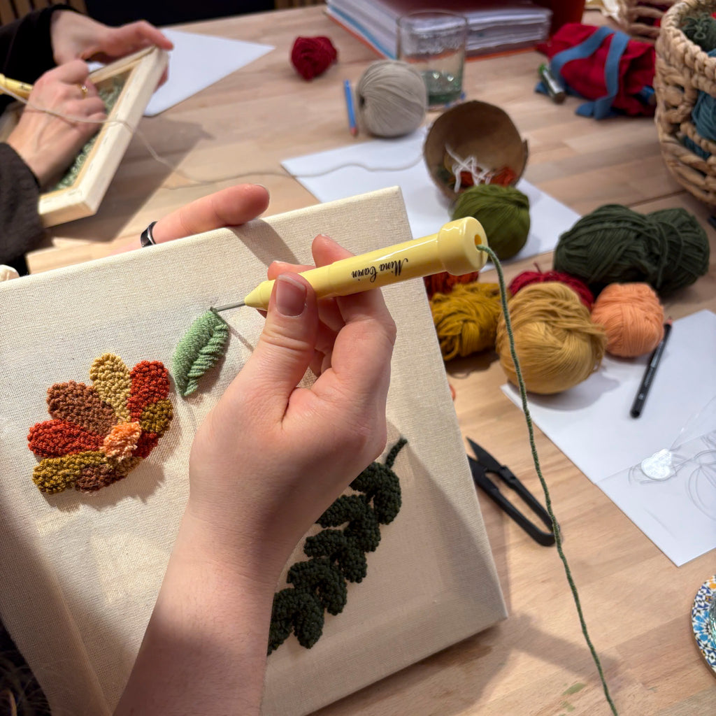 Beim StraightCurls Punch Needle Workshop FFB Emmering wird mit einer Stanznadel ein Blattmotiv auf Leinwand gestanzt.