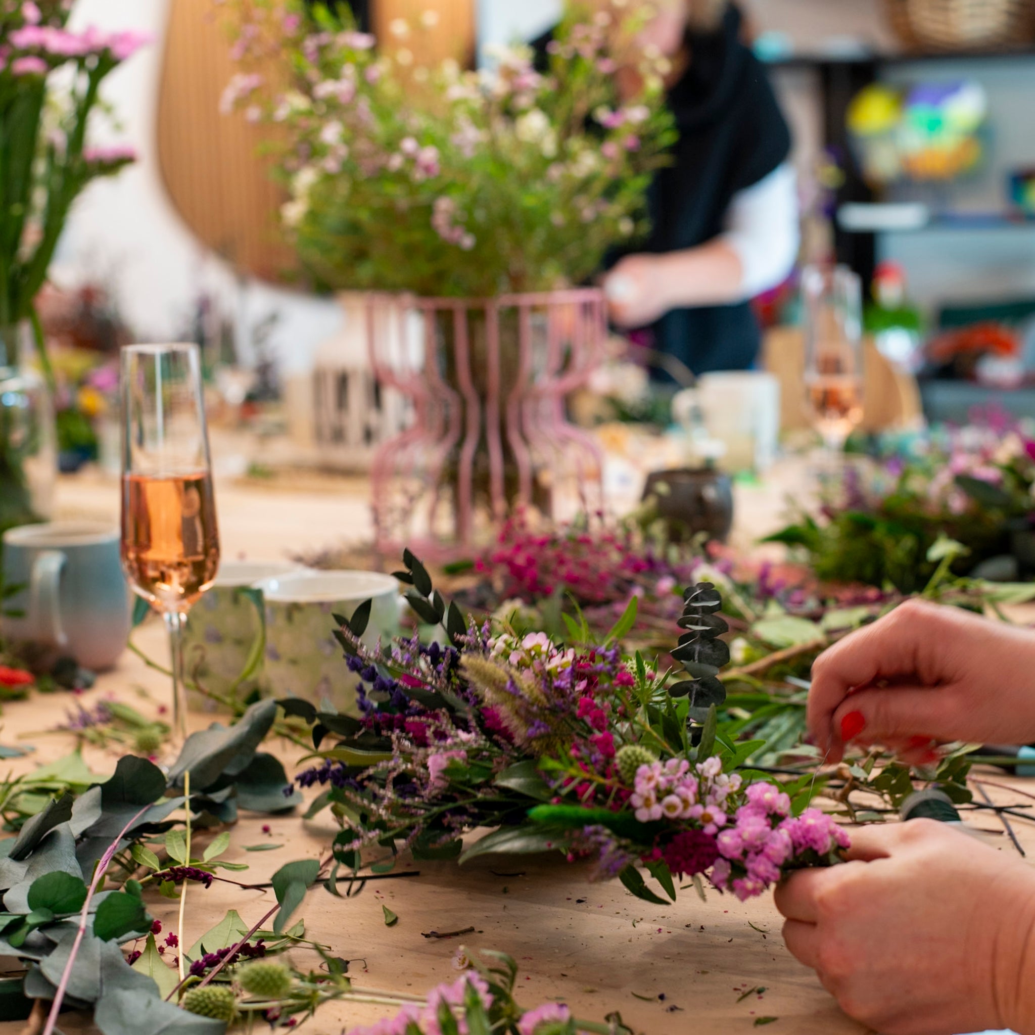 Geselliges Gestalten floraler Kränze in entspannter Atmosphäre mit Erfrischungen bei StraightCurls.