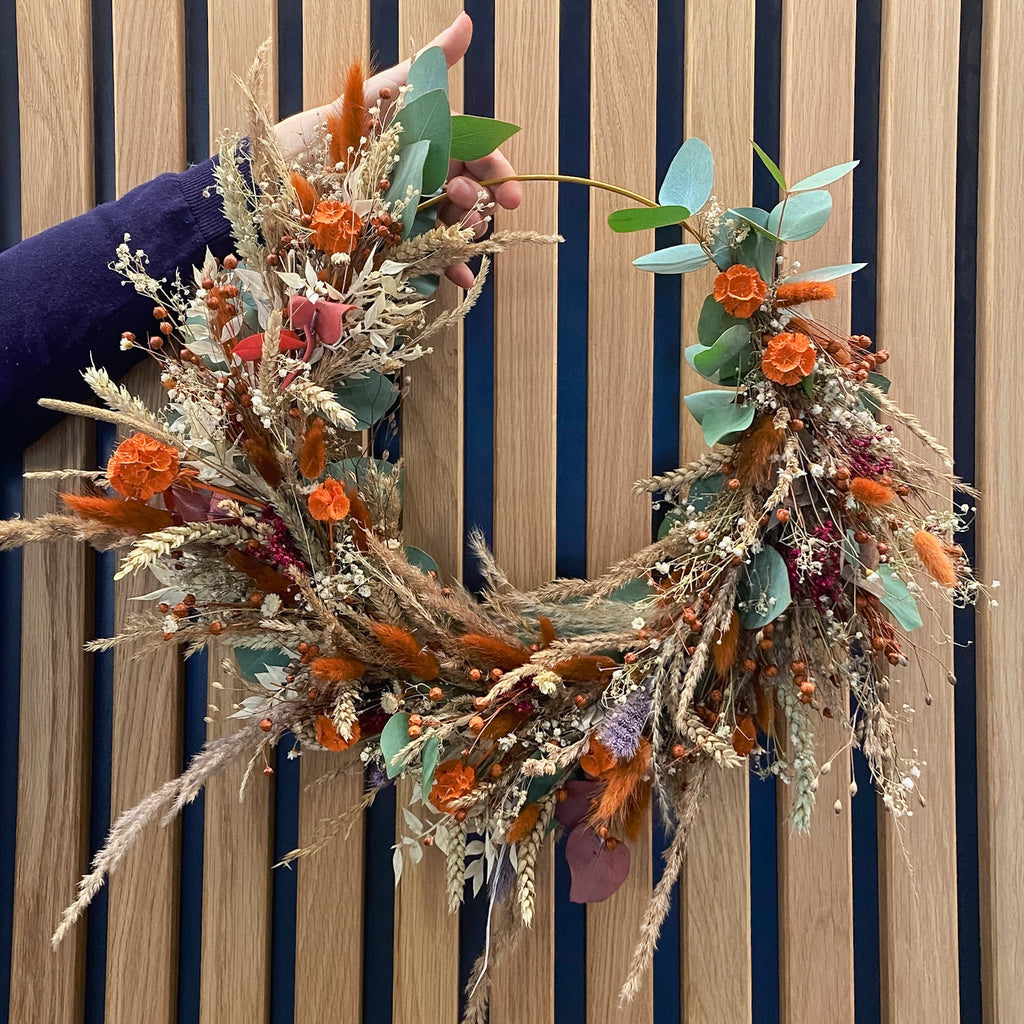 Langlebiger Kranz in warmen Orange- und Naturtönen, handgebunden bei StraightCurls.