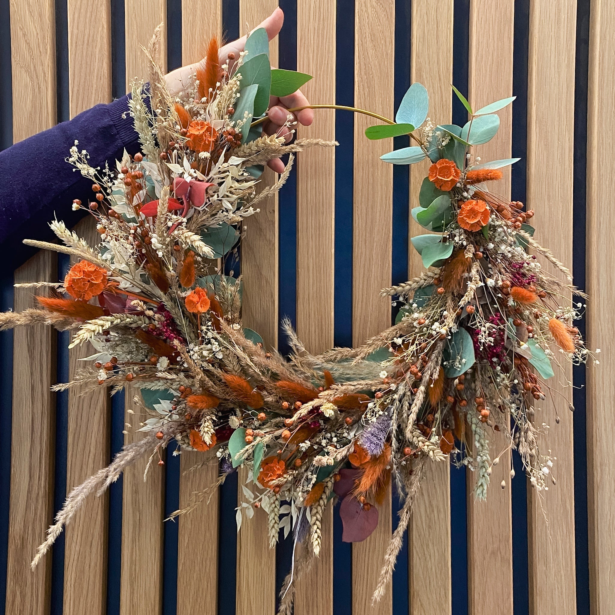 Langlebiger Kranz in warmen Orange- und Naturtönen, handgebunden bei StraightCurls.