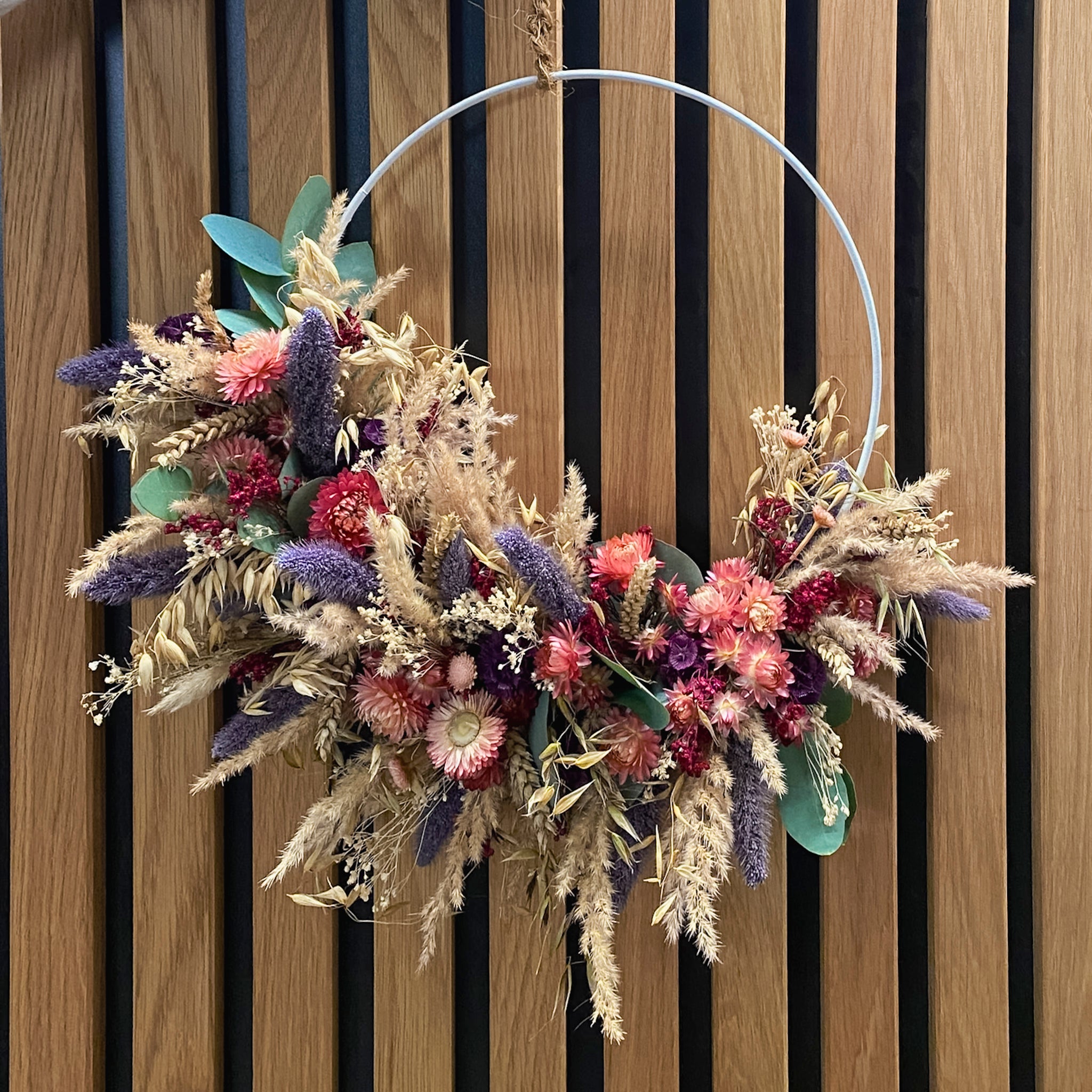 Zarter Blumenkranz auf weißem Ring mit rosa Akzenten, gefertigt bei StraightCurls.