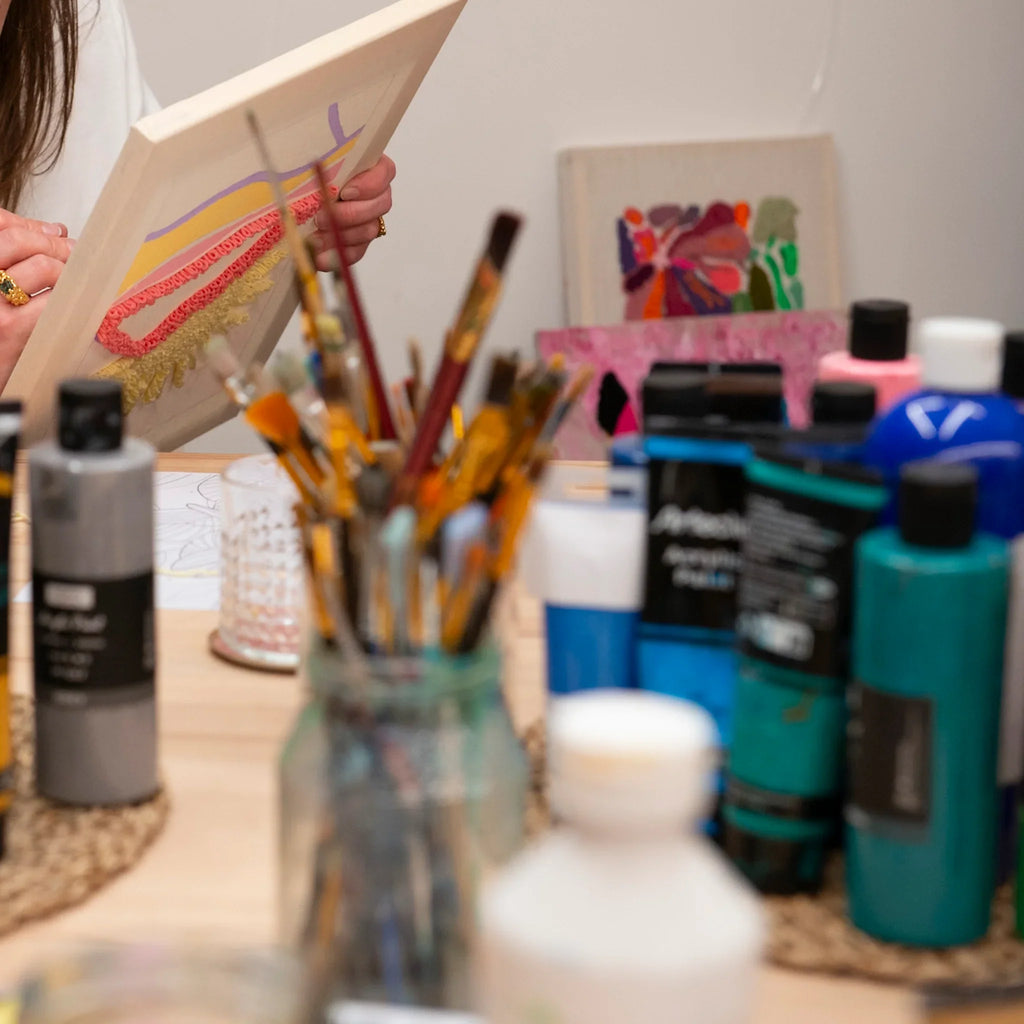 Eine Person, die mit Punch Needle und Acrylfarben im StraightCurls Workshop in FFB Emmering einzigartige Designs kreiert.